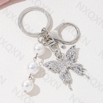 Eprolo keychain featuring a heart, butterfly, and star details, made of metal with intricate decorative design.