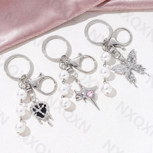 Eprolo keychain featuring heart, butterfly, and star details, with intricate metal design and colorful accents.