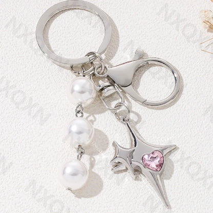 Eprolo keychain with butterfly, heart, and star details in metal, featuring intricate engraved designs and a keyring attachment.