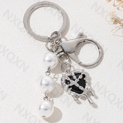 Eprolo keychain featuring heart, butterfly, and star details with colorful, intricate design on a solid background.