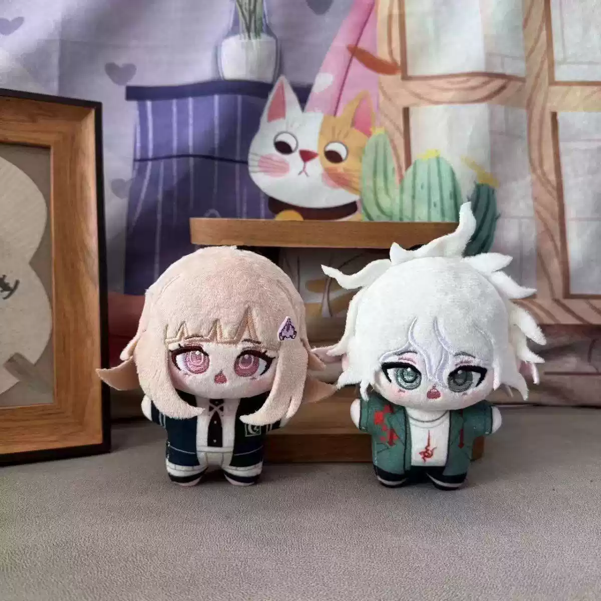 Soft plush toys of Kokichi Oma, Chiaki Nanami, and Nagito Komaeda from Danganronpa by Shadora, shown in a cozy display.